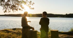 two men having a conversation outside by a lake | eating disorder.care